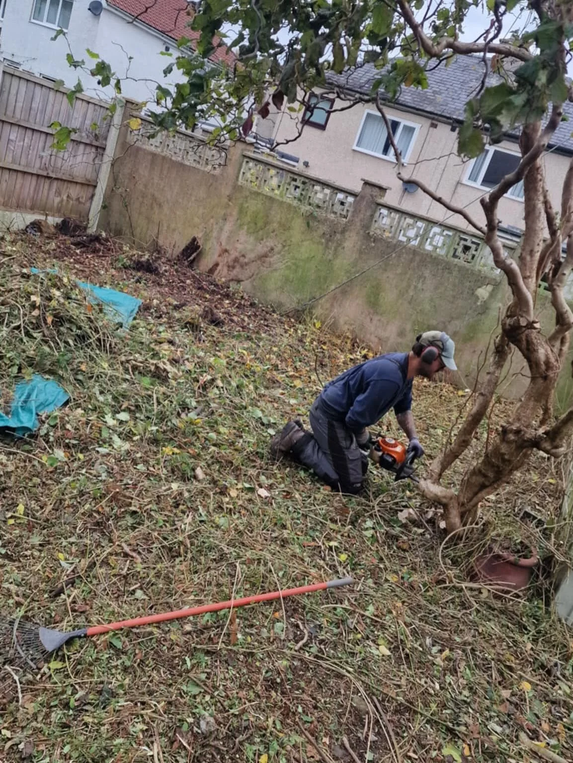 A team member cutting vegetation during garden clearance work